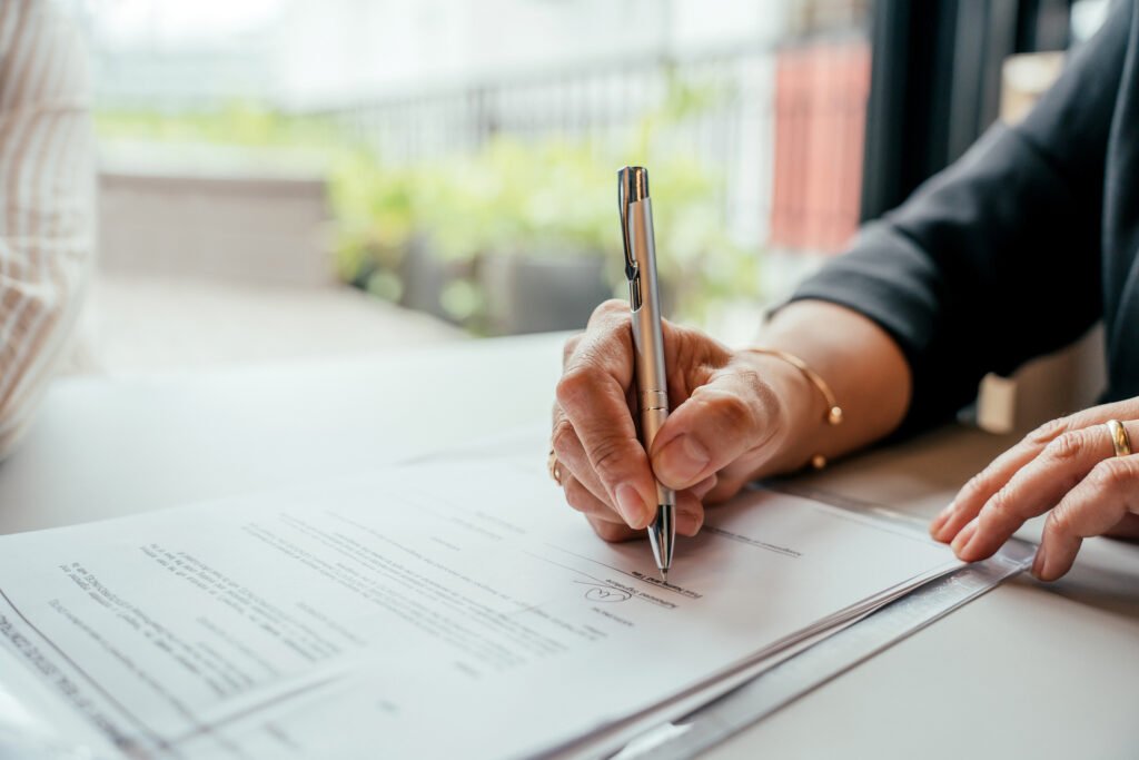 Professional signing business contract documents during a transaction or agreement process