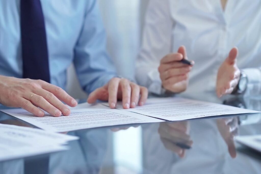 Two business professionals reviewing and discussing documents at a table