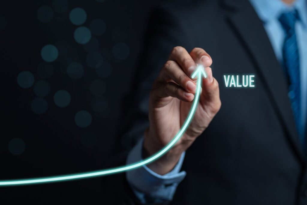 Business professional illustrating an upward growth curve next to the word ‘Value,’ representing increasing business value and performance.