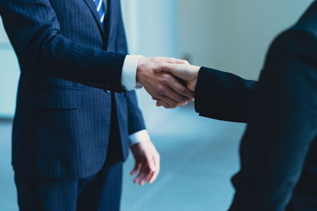Two business professionals shaking hands to represent a partnership or business agreement