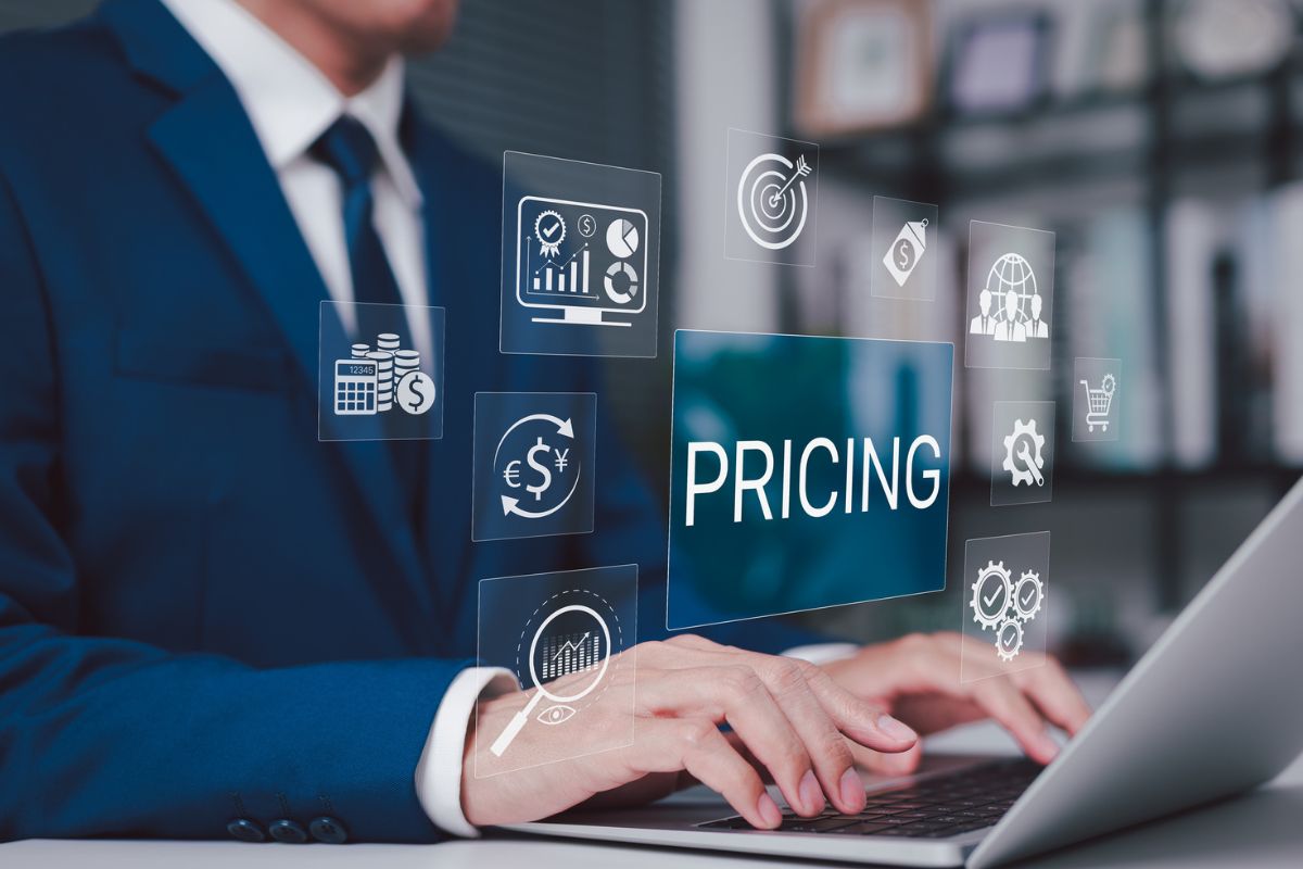 Business professional using a laptop with pricing and financial strategy icons