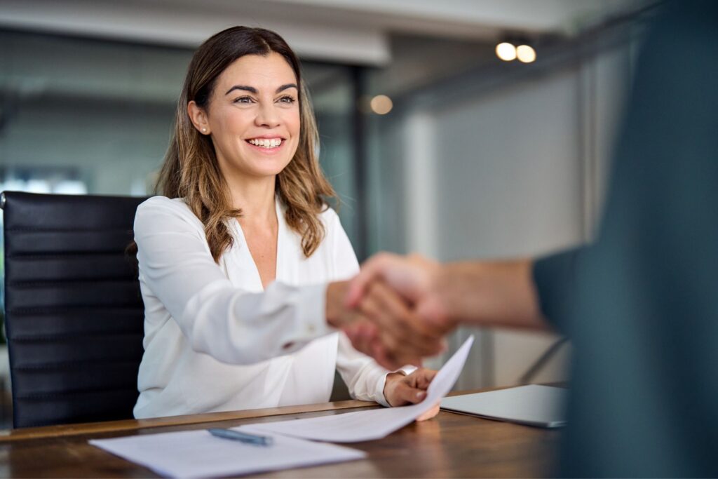 Business ownership transfer agreement with professionals shaking hands