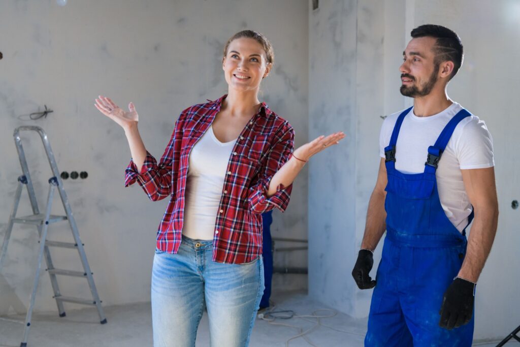 Two people discussing a project inside an unfinished building.